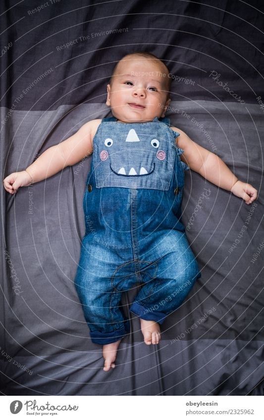 cute baby lying in a bead wearing jean dungarees Happy Beautiful Face Bathroom Child Human being Baby Toddler Boy (child) Woman Adults Infancy Toys Smiling