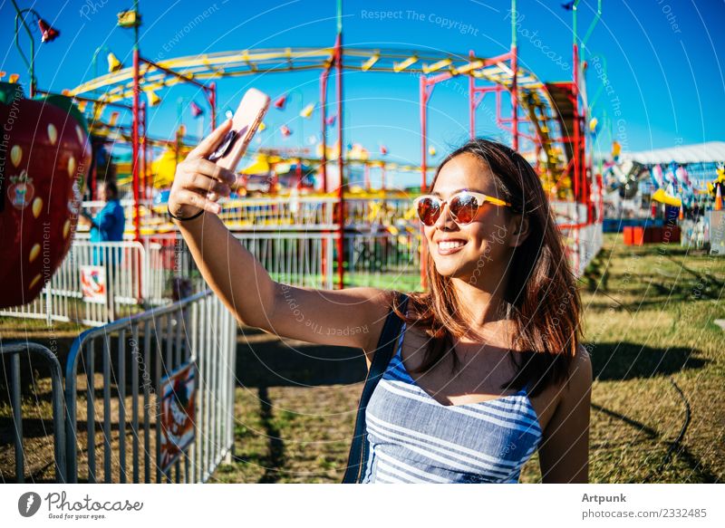 A woman taking a selfie at an amusement park Amusement Park Colour Multicoloured Selfie Ride PDA Technology Sunglasses Portrait photograph Fairs & Carnivals Joy