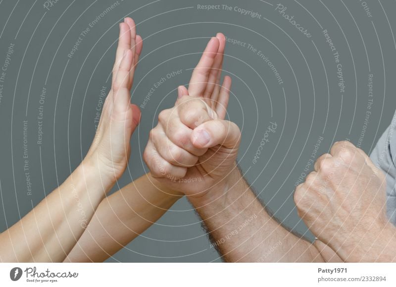 Woman has raised both hands defensively against a man who threatens her with clenched fists. Detail of the hands. Human being Masculine Feminine Adults Man Arm