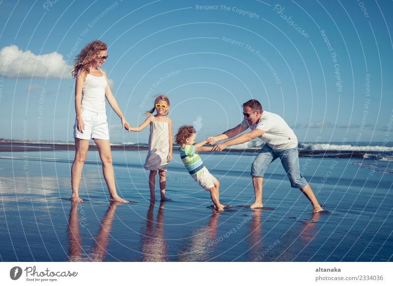 Happy family walking on the beach at the day time. Concept of friendly family. Lifestyle Joy Leisure and hobbies Playing Vacation & Travel Trip Freedom Summer