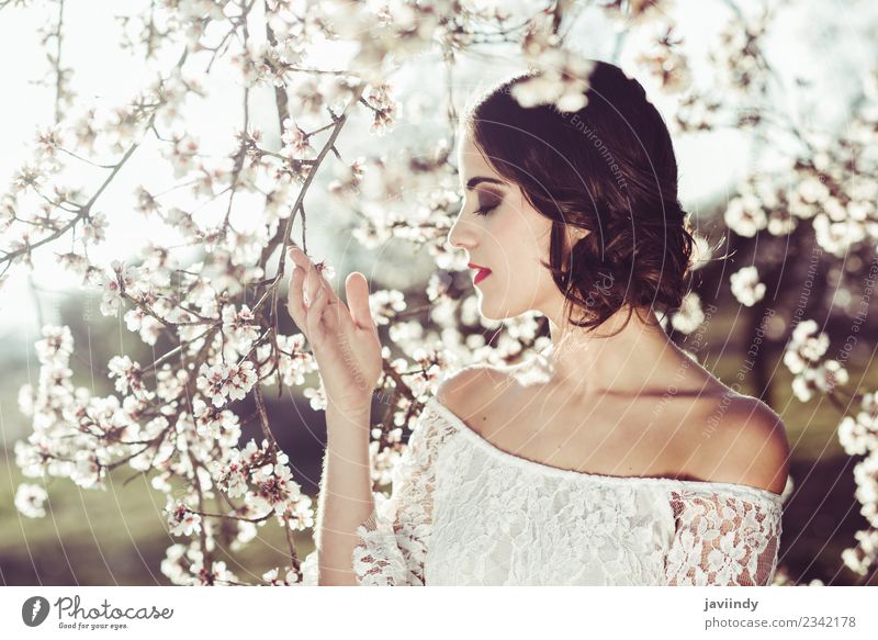 Young woman smelling almond flowers in springtime Style Happy Beautiful Hair and hairstyles Face Human being Woman Adults Nature Tree Flower Blossom Park