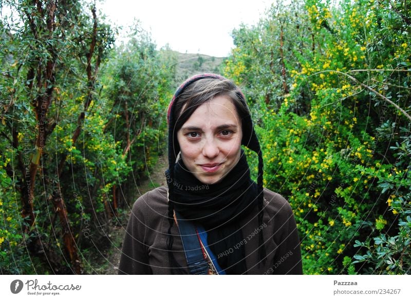 Cil in the Peruvian thicket Portrait photograph Cap Looking into the camera Laughter Bushes Hedge Blossom Feminine Scarf Sympathy Copy Space left