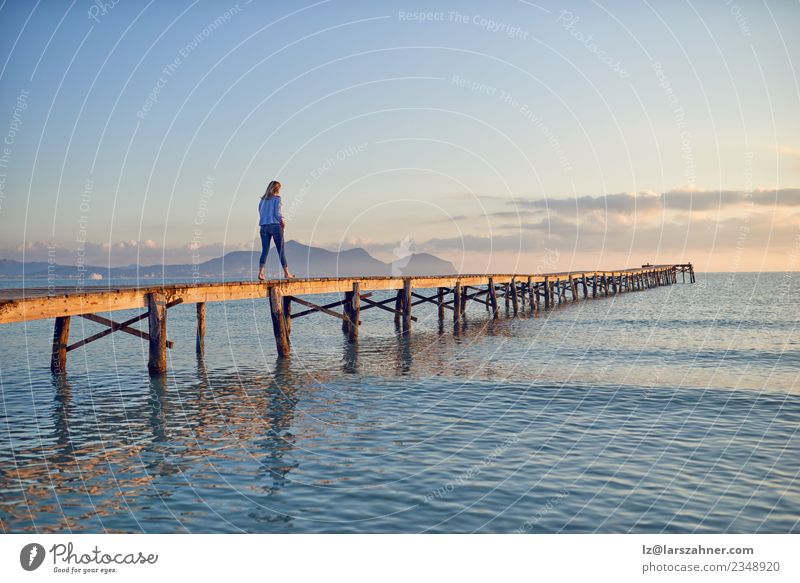 Woman walking along a wooden pier at sunset Lifestyle Beautiful Relaxation Leisure and hobbies Vacation & Travel Tourism Freedom Summer Sun Beach Ocean Adults 1