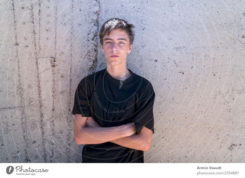 Youth with crossed arms in front of a concrete wall in summer Lifestyle Style pretty Human being Masculine Young man Youth (Young adults) Arm 1 13 - 18 years