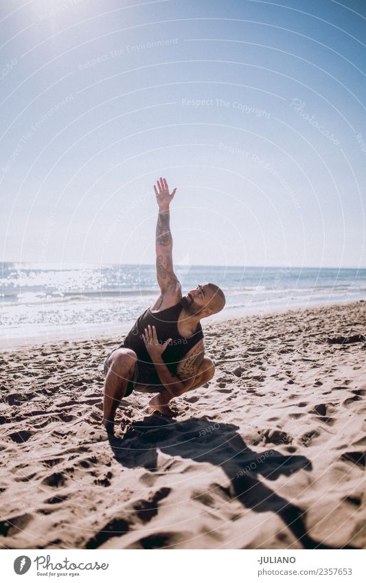 Young man is doing yoga at the beach Sports workout Yoga Warming up Beach Sun Fitness Sports Training Hard Perspire Musculature Joy Sportsperson