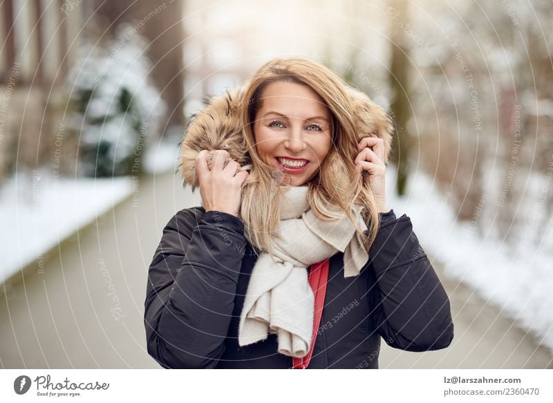Friendly young blond woman outdoors in winter Lifestyle Happy Beautiful Face Winter Snow Woman Adults Park Fashion Coat Fur coat Scarf Blonde Smiling Happiness