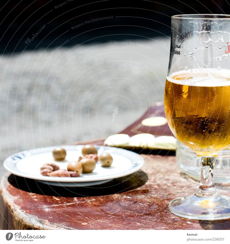 holiday lunch Food Olive Nutrition Beverage Cold drink Alcoholic drinks Beer Plate Glass Beer glass beer tulip Table Wood Lie Green olive stone Colour photo