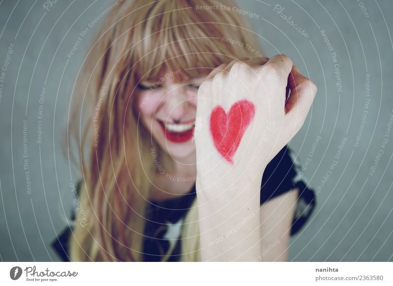 Cheerful young woman with a red heart painted in her hand Lifestyle Style Design Joy Happy Hair and hairstyles Wellness Human being Feminine Young woman