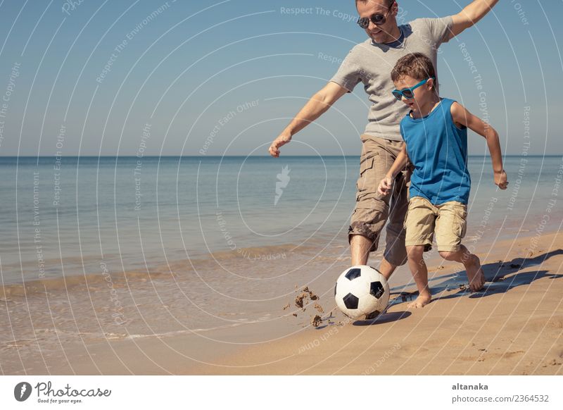 Father and son playing football on the beach at the day time. Concept of friendly family. Lifestyle Joy Happy Relaxation Playing Vacation & Travel Trip