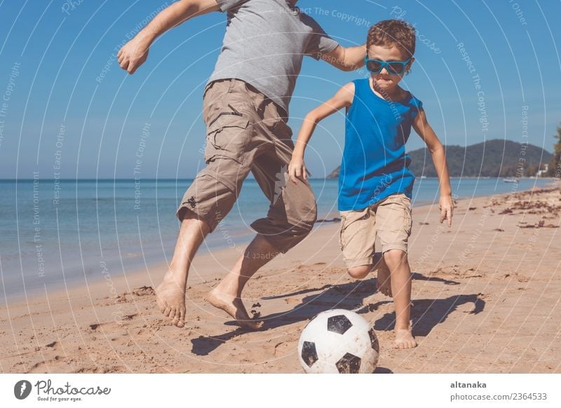 Father and son playing football on the beach at the day time. Lifestyle Joy Happy Relaxation Playing Vacation & Travel Trip Adventure Freedom Camping Summer