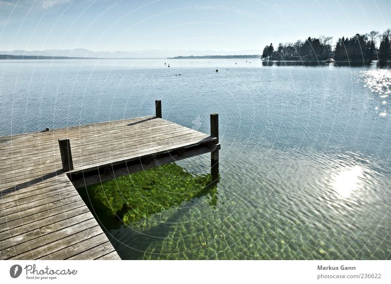 jetty at the lake Relaxation Calm Vacation & Travel Nature Lake Blue Gray Jetty Footbridge Wood Reflection Sun Horizontal Lakeside Wet Warmth Colour photo