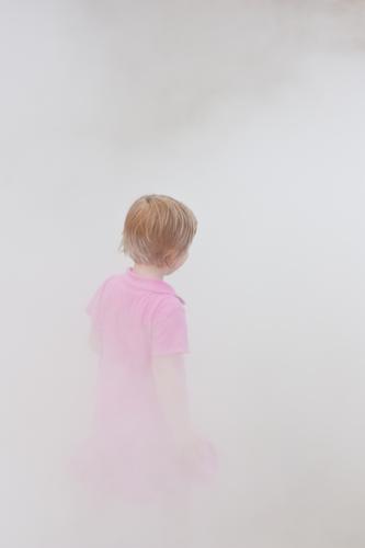 Child in the fog Girl Head Hair and hairstyles 1 Human being 3 - 8 years Infancy Air Fog Dress Gray Pink Subdued colour Exterior shot Neutral Background Day