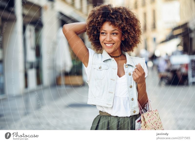Young black woman, afro hairstyle, with shopping bags in the street. Lifestyle Shopping Style Happy Beautiful Hair and hairstyles Human being Feminine