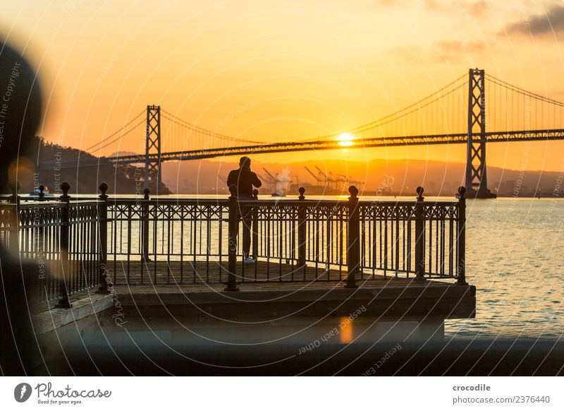 # 750 Oakland Bay Bridge San Francisco Harbour Ocean Sunrise Jetty Man Photographer Calm Back-light Colour photo Orange Light Suspension bridge Loneliness