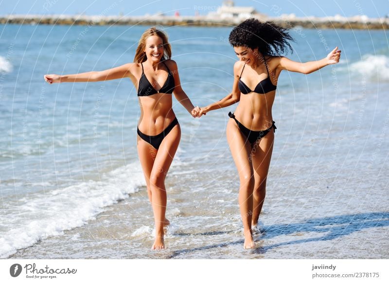 Two young women in having fun a tropical beach - a Royalty Free Stock Photo Photocase