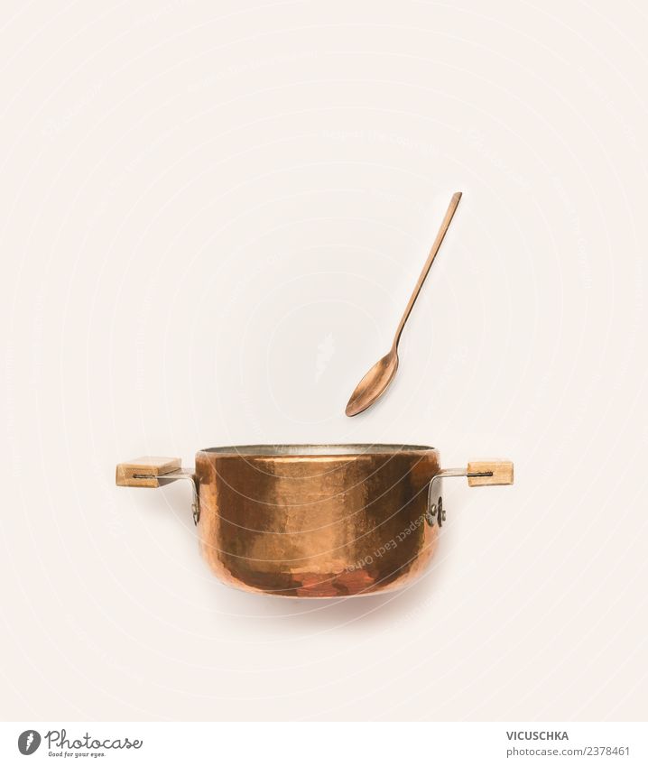 Copper pot with spoon on white background. Crockery Pot Spoon Style Design Restaurant Wooden spoon Bright background Things Colour photo Interior shot