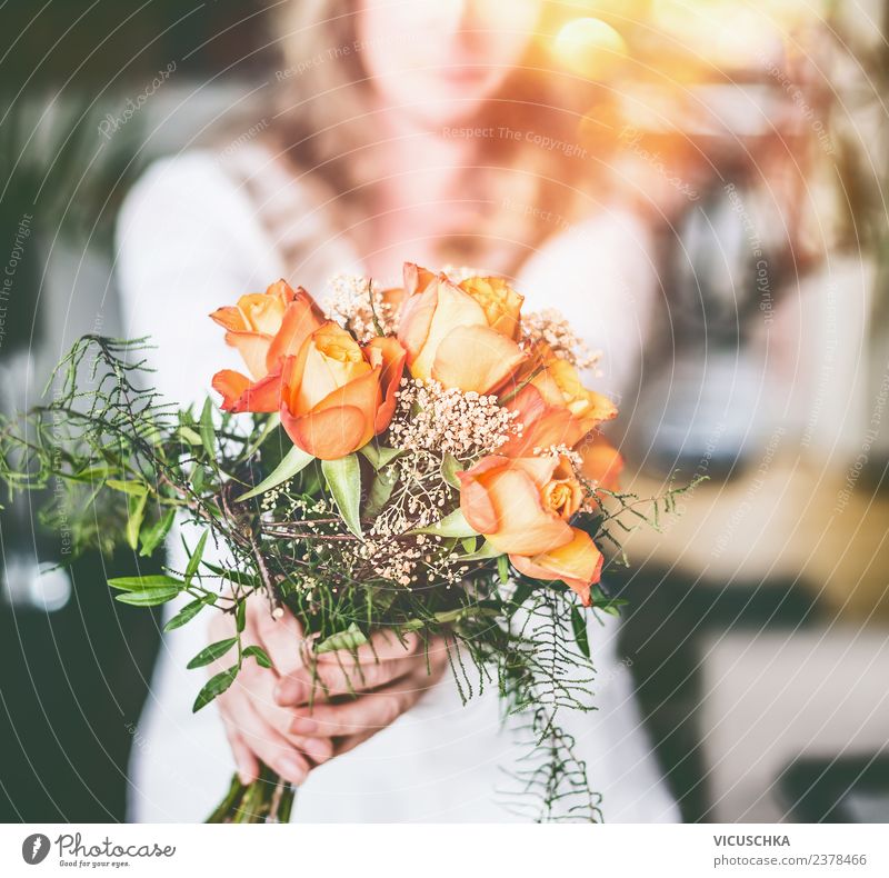 Orange roses in female hands Lifestyle Design Feasts & Celebrations Feminine Woman Adults Hand Flower Rose Bouquet Love Emotions Moody Sun Blur Gift