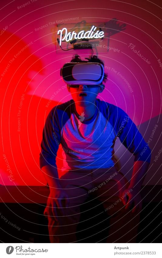 A young man enjoying a VR experience Paradise Virtual Neon light Signage Red Blue flash Gel Headset Technology Computer Illustration Visual spectacle Experience