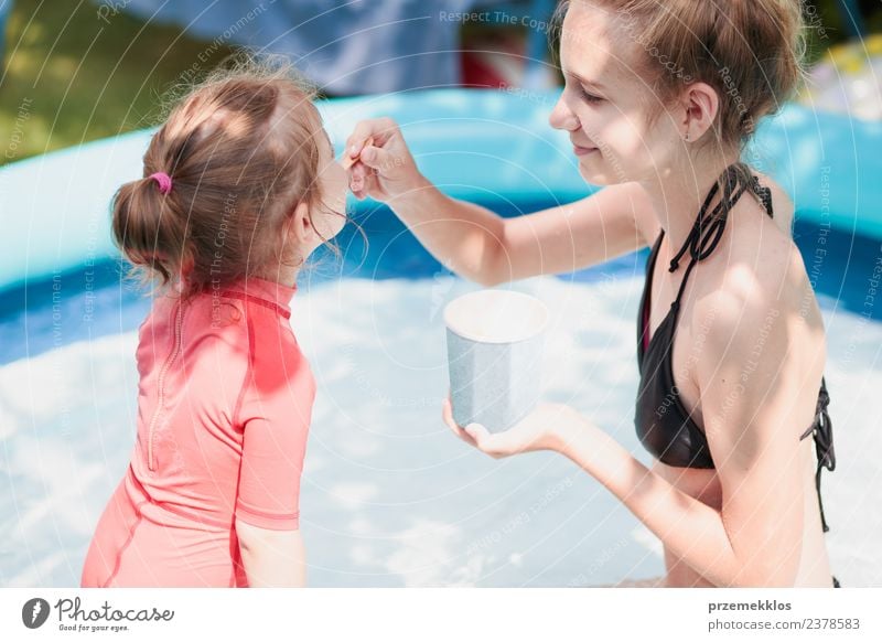 Teenage girl with her little sister enjoy eating ice cream Dessert Ice cream Eating Lifestyle Joy Happy Beautiful Swimming pool Leisure and hobbies
