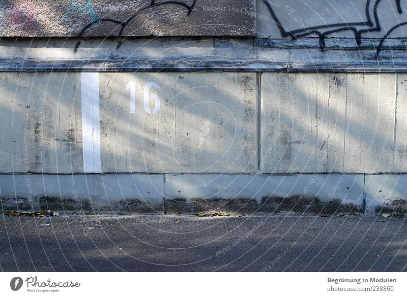 16 Wall (barrier) Wall (building) Digits and numbers Signs and labeling Graffiti Parking lot Parking space number Shadow Colour photo Exterior shot Deserted
