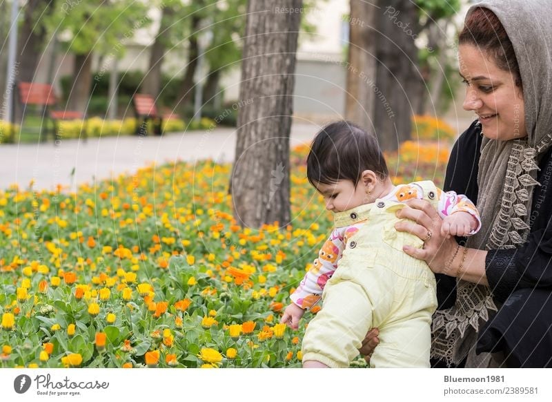 Muslim mother holding Little baby inside spring flowers at park Lifestyle Joy Beautiful Playing Garden Parenting Child Human being Baby Girl Young woman