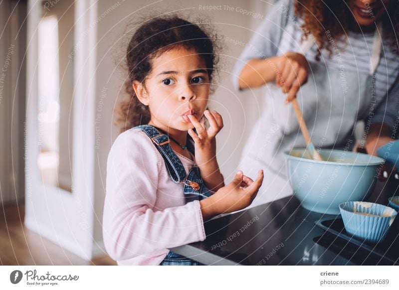 little african girl is licking dough from fingers Dessert Joy Happy Beautiful Kitchen Child Human being Woman Adults Mother Infancy Fingers Together Small