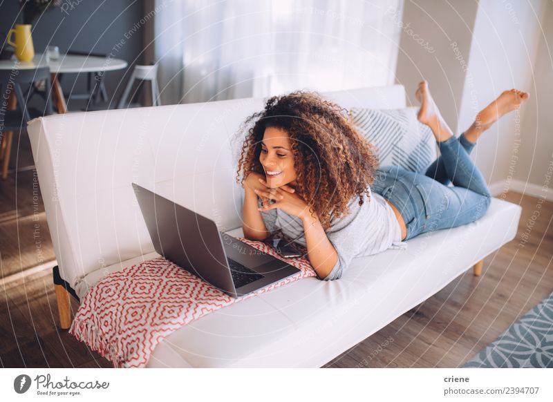african happy woman lying on couch with laptop Lifestyle Happy Beautiful Relaxation Sofa Work and employment Computer Notebook Technology Internet Woman Adults