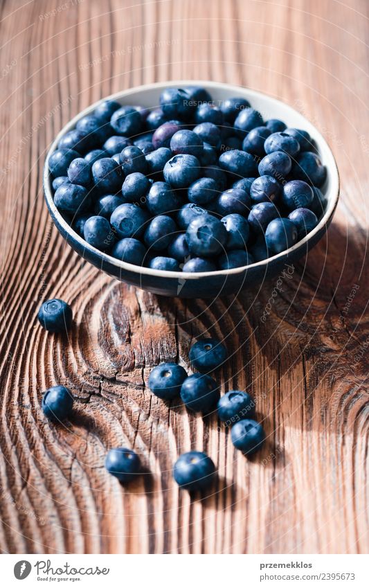 Freshly gathered blueberries put into ceramic bowl Food Fruit Nutrition Organic produce Vegetarian diet Diet Bowl Summer Table Nature Wood Authentic Delicious