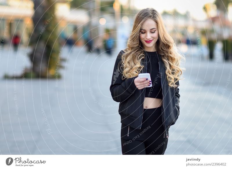 Blonde woman texting with her smart phone outdoors Lifestyle Style Beautiful Hair and hairstyles Telephone PDA Human being Woman Adults Autumn Street Fashion