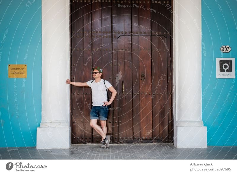 young man waits at a wooden door and supports himself Cuba Havana Island Vacation & Travel Travel photography Trip Sightseeing Street Town Blue Wanderlust Day