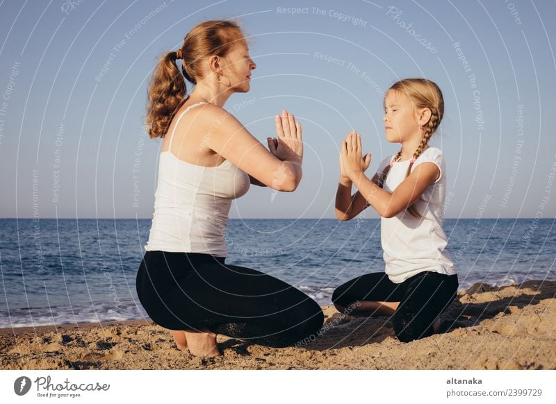 Mother and daughter doing yoga exercises on the beach. Lifestyle Joy Happy Body Wellness Harmonious Relaxation Meditation Leisure and hobbies Camping Summer