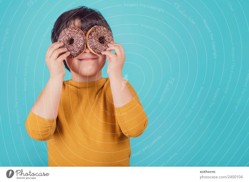 smiling boy holding donuts over her eyes Food Roll Nutrition Breakfast Lunch Lifestyle Human being Masculine Child Toddler Infancy 1 8 - 13 years To hold on