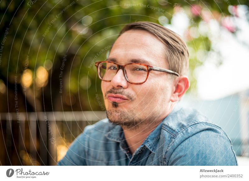 Portrait of a young man with glasses Day Exterior shot Portrait photograph 1 Person Young man Person wearing glasses Eyeglasses Facial hair Moustache