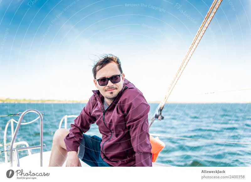 young man sits on a sailboat on the sea Day 1 Person Portrait photograph Young man Short haircut Sunglasses Water Ocean Sailing Sailboat Maritime Lake Blue sky