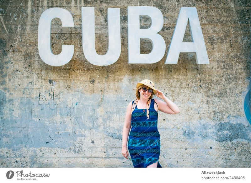 Woman with blue dress and hat before the word CUBA Day Feminine 1 Person Young woman Wall (barrier) Wall (building) Cuba Letters (alphabet) Typography Word
