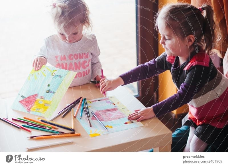 Two little girls drawing the colorful pictures Lifestyle Joy Happy Handcrafts Table Education Kindergarten Child School Craft (trade) Human being Girl Sister