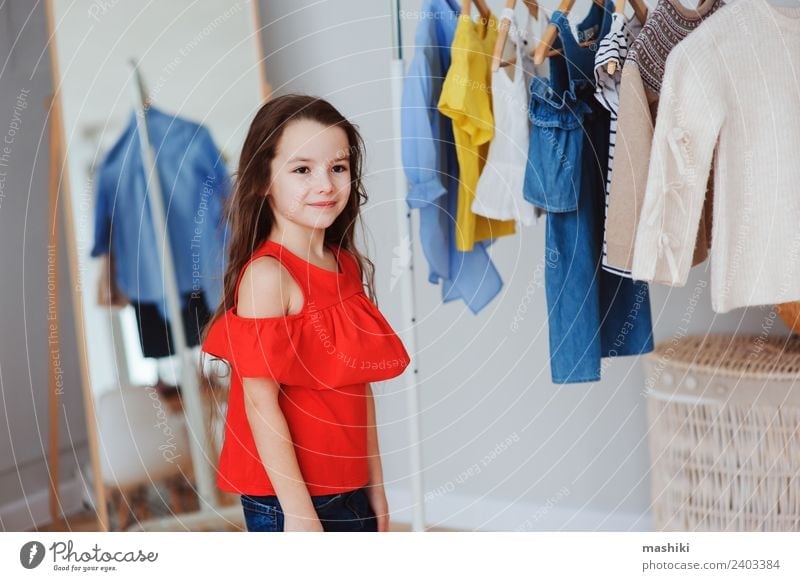 cute little child girl choosing new clothes Shopping Style Child Fashion Clothing Dress Collection Smiling Bright Hip & trendy Small Modern New Red Colour kid