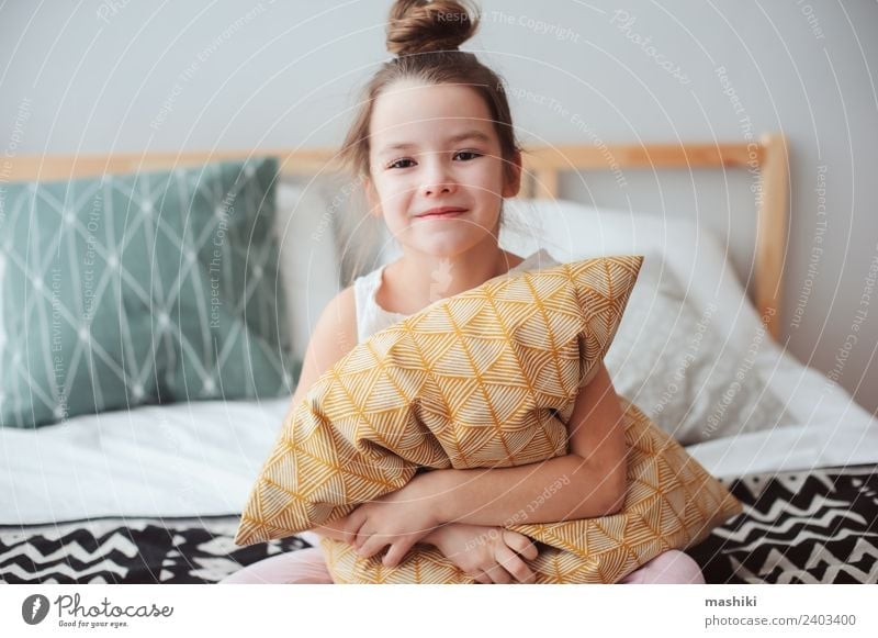 happy child girl sitting on bed and hugs pillow Lifestyle Joy Relaxation Bedroom Child Smiling Sleep Dream Small Funny Cute Comfortable Energy kid Wake up