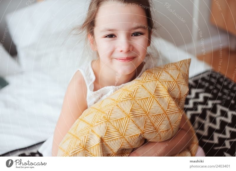 happy child girl sitting on bed and hugs pillow Lifestyle Joy Relaxation Sun Bedroom Child Toys Teddy bear Smiling Sleep Dream Small Funny Cute Comfortable