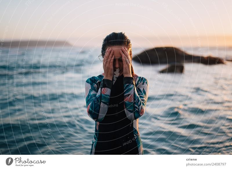 caucasian woman in wetsuit by sunset Ocean Woman Adults Hand Rock Brunette Wet Blue Brown Surfing Wetsuit Sunset water young Caucasian hiding background