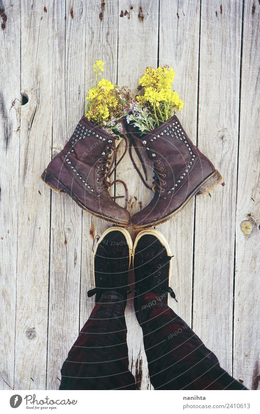 Someone in front of old boots filled with flowers Style Design Legs Nature Plant Flower Wild plant Pot plant Clothing Footwear Boots Sneakers Wood Leather Old