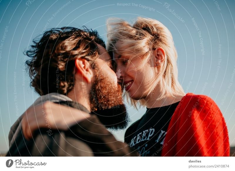 Blonde woman and bearded man kissing portrait with beautiful sunset light. Lifestyle Joy Woman Adults Man Couple Beard Kissing Smiling Love Embrace Cool (slang)
