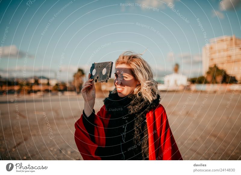 Blonde woman holding a video tape Lifestyle Joy Happy Beautiful Leisure and hobbies Sun Camera Technology Human being Young woman Youth (Young adults) Woman