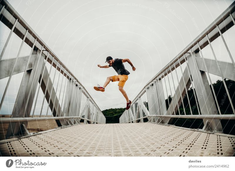 Man jumping on a bridge. Lifestyle Vacation & Travel Trip Adventure Human being Adults 1 18 - 30 years Youth (Young adults) Environment Nature Bridge Clothing