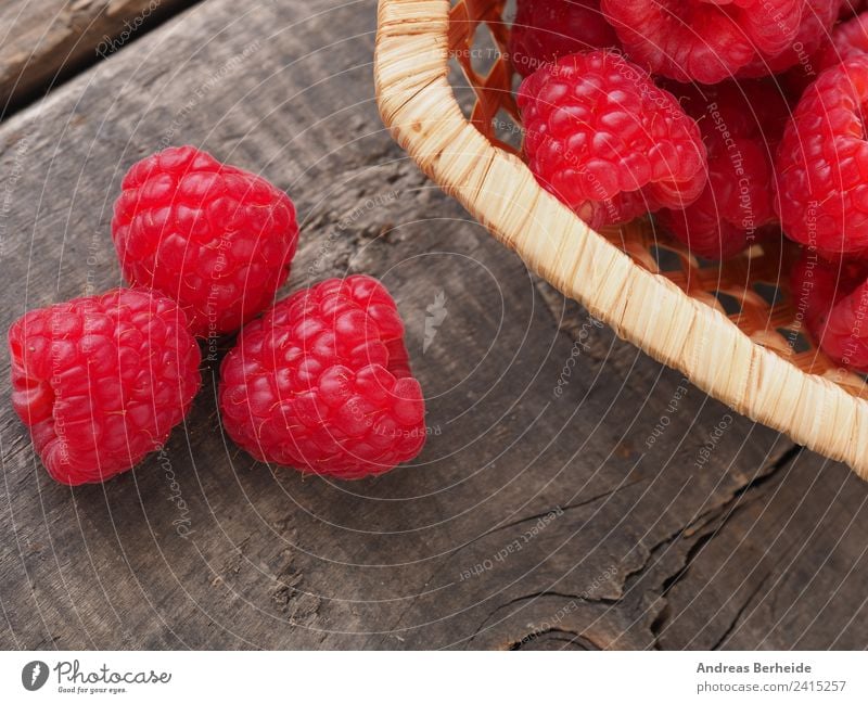 Organic raspberries on a wooden table Fruit Dessert Organic produce Vegetarian diet Style Healthy Eating Summer Garden Nature Delicious natural raw red ripe