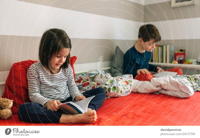 Girl and boy reading book sitting on bed Lifestyle Beautiful Calm Reading Bedroom Child School Human being Boy (child) Woman Adults Man Sister