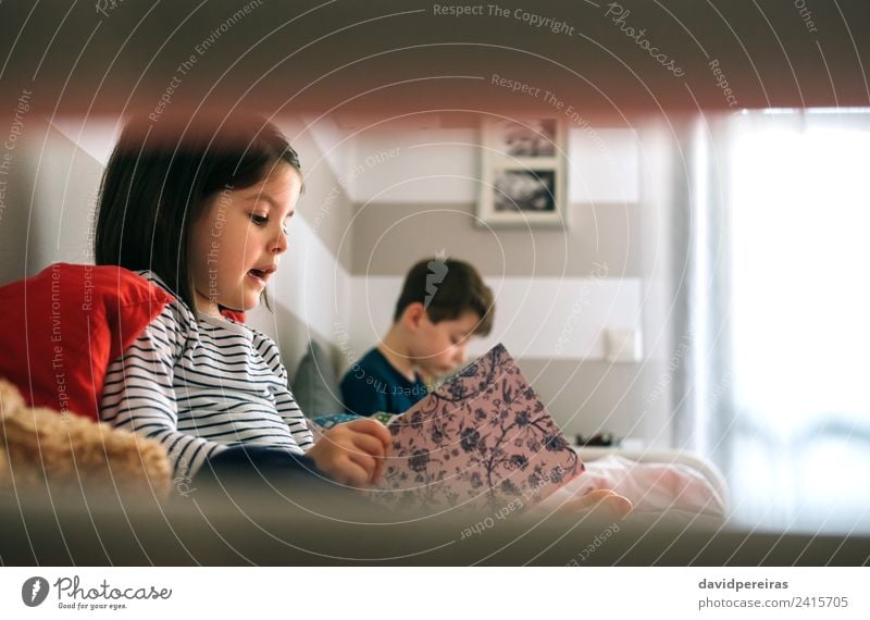 Girl and boy reading a book each sitting on the bed Lifestyle Beautiful Calm Reading Bedroom Child School Human being Boy (child) Woman Adults Man Sister