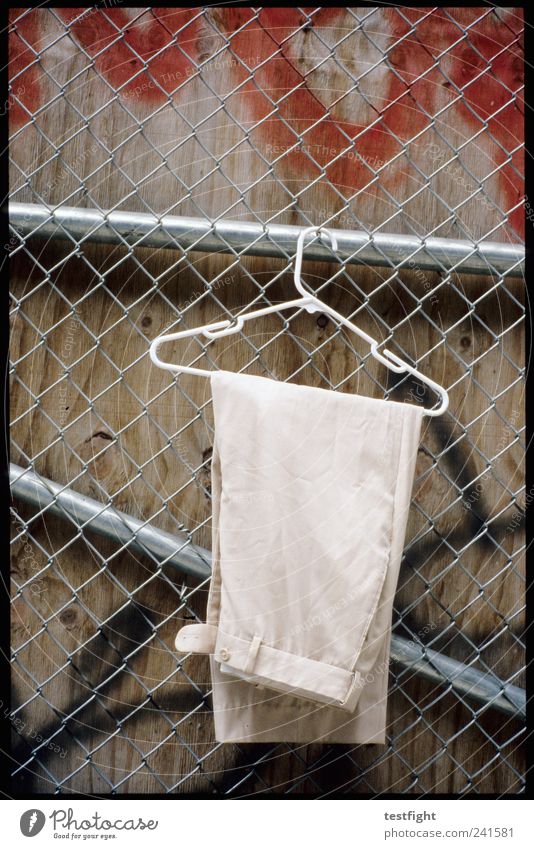 pants Fashion Clothing Pants Hang Wait Hanger Fence Wire netting fence Wall (building) Graffiti Colour photo Exterior shot