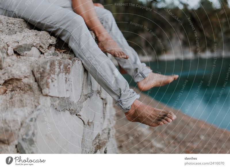 Man and woman legs hanging from a wall Lifestyle Leisure and hobbies Vacation & Travel Human being Woman Adults Couple Partner Legs Feet Nature Lake River Jeans
