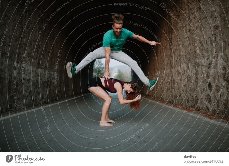 Man leapfrog jumping over woman on a road Joy Life Playing Freedom Human being Woman Adults Friendship Couple Youth (Young adults) 2 18 - 30 years Dancer Nature